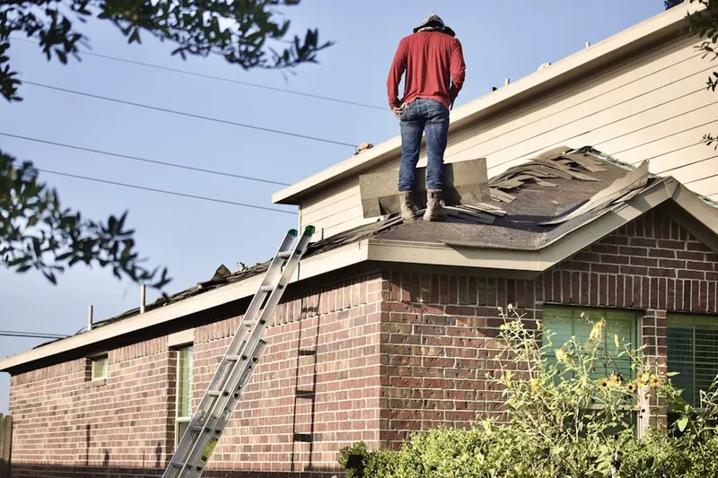 Professional roofer working on a residential roof in Colby
